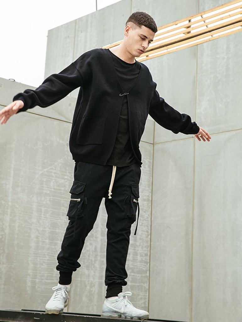 Man  in black cargo pants standing on a wall in an urban environment
